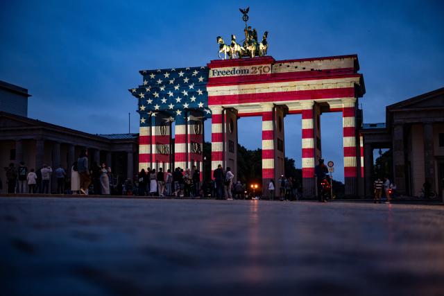04 July 2026, Berlin: People look at the Brandenburg Gate, which is illuminated in the colors of the United States of America to mark the 250th anniversary of American independence. Photo: Fabian Sommer/dpa