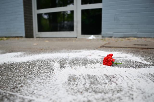 06 July 2026, Berlin: Powder used to absorb liquids and a red flower lie at the spot where a man fell from a balcony onto the sidewalk during a police operation. Photo: Sebastian Gollnow/dpa
