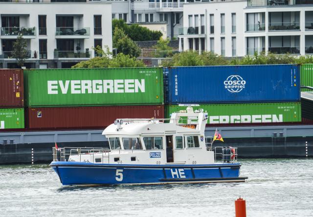 FILED - 28 August 2025, Hesse, Ruedesheim: FILE PHOTO - A police boat passes Evergreen container ship on the Rhine. Photo: Andreas Arnold/dpa