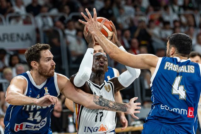 06 July 2026, Bavaria, Bamberg: Germany's Dennis Schroeder (C), Cyprus' Kyprianos Maragkos (L), and Cyprus' Ioannis Pashialis battle for the ball during the Basketball World Cup Qualifiers Group E Basketball match between Germany and Cyprus. Photo: Daniel Löb/dpa