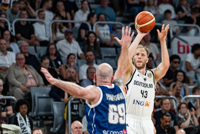 06 July 2026, Bavaria, Bamberg: Germany's Christian Sengfelder (R) in action as he sinks a three-pointer against Cyprus' Roberto Mantovani during the Basketball World Cup Qualifiers Group E Basketball match between Germany and Cyprus. Photo: Daniel Löb/dpa