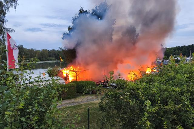 07 July 2026, Bavaria, Eschenbach in der Oberpfalz: Smoke and blaze rise from a fire at a camp ground in Grosskotzenreuth, in the district of Neustadt an der Waldnaab. Photo: Jürgen Masching/NEWS5/dpa