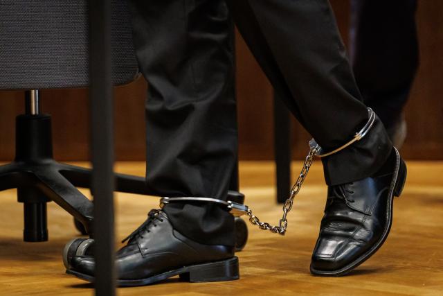 07 July 2026, Bavaria, Nuremberg: A defendant wearing ankle monitors arrives at the start of his trial in the courtroom of the Criminal Justice Center at the Nuremberg-Fuerth Regional Court. The man, from Middle Franconia, is accused of having instructed the child's mother to allow the abuse of the child-who was between eight and eleven years old-over a period of three years. Photo: Daniel Karmann/dpa