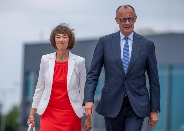 07 July 2026, Brandenburg, Schoenefeld: German Chancellor Friedrich Merz and his wife Charlotte Merz walk toward the plane at Berlin-Brandenburg Airport to fly to the NATO summit in Turkey. Photo: Michael Kappeler/dpa
