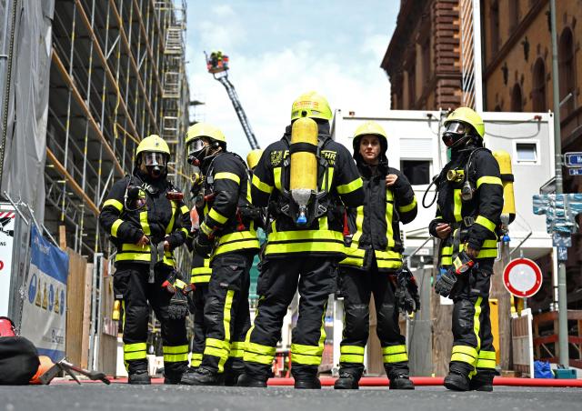 07 July 2026, Hesse, Frankfurt am Main: Firefighters stand in front of a house as they battle a fire in the city centre. Photo: Jennifer Brückner/dpa