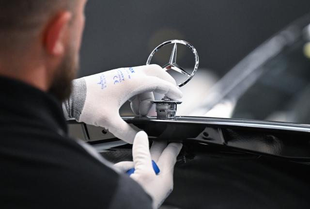 FILED - 30 April 2026, Baden-Württemberg, Sindelfingen: FILE PHOTO - A Mercedes-Benz worker attaches the Mercedes star on an S-Class vehicle at the company's plant in Sindelfingen. Photo: Bernd Weißbrod/dpa