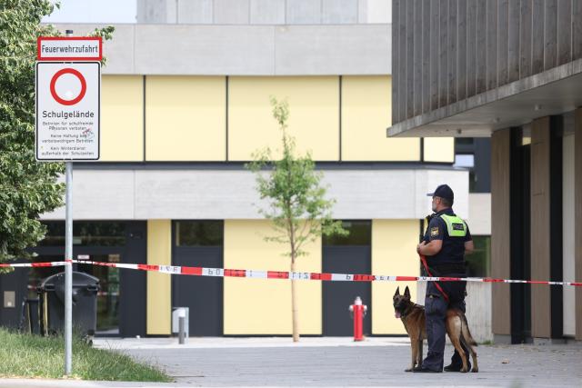 08 July 2026, Bavaria, Schongau: A police officer with a dog stands outside Welfen High School following an incident that left several people injured and resulted in one arrest. Police said there are strong indications the incident was a rampage. Photo: Karl-Josef Hildenbrand/dpa