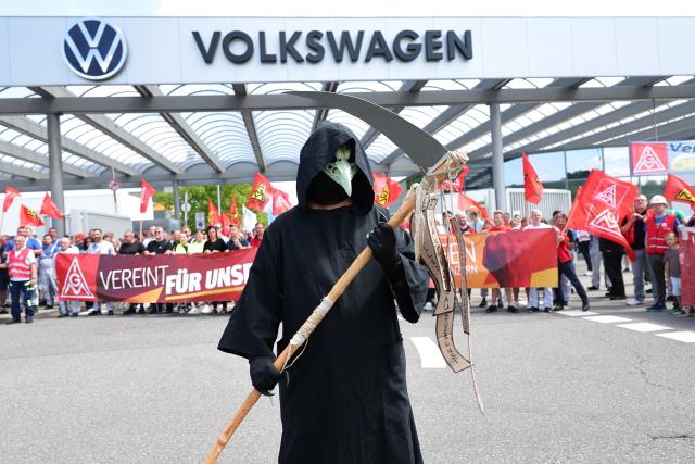 09 July 2026, Lower Saxony, Zwickau: Volkswagen employees participate in an information and protest event organized by IG Metall in front of the VW plant in Zwickau, on the day of the Volkswagen AG supervisory board meeting in Wolfsburg. IG Metall is organizing information and protest events nationwide at numerous company locations. Photo: Jan Woitas/dpa