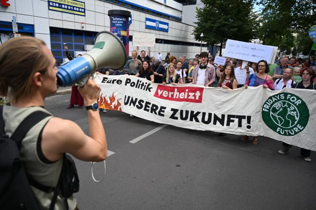 10 July 2026, Berlin: Protesters holding a sign that reads "Your policies are squandering our future!" take part in a Fridays for Future protest. Fridays for Future has called for nationwide demonstrations demanding the resignation of Federal Minister of Economic Affairs Reiche. Photo: Markus Lenhardt/dpa