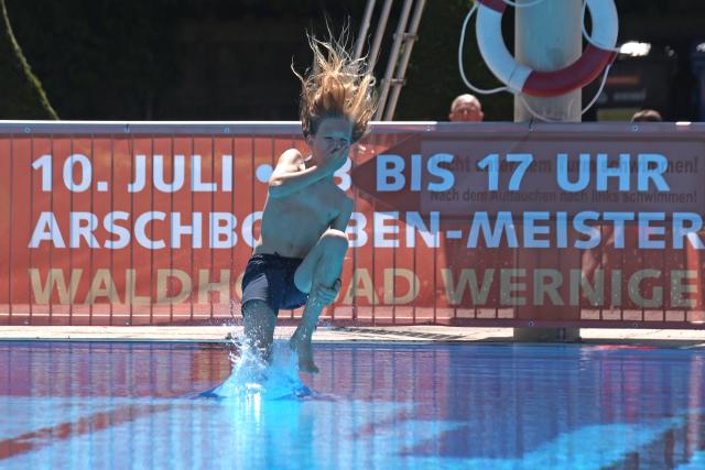 10 July 2026, Saxony-Anhalt, Wernigerode: A boy jumps into the cool water at the Waldhofbad in Wernigerode as a participant in the cannonball championship. Photo: Matthias Bein/dpa