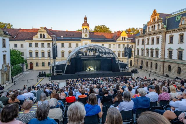 10 July 2026, Bavaria, Regensburg: Audience members sit in the inner courtyard of St. Emmeram Prince's Palace during the Thurn und Taxis Castle Festival. Photo: Armin Weigel/dpa