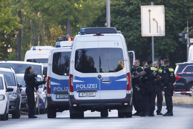11 July 2026, Berlin: Police officers stand guard and secure a perimeter outside a supermarket, following reports of an active hostage situation inside the building. Special operations units have deployed to the scene, and local authorities have cordoned off the surrounding streets. Photo: Carsten Koall/dpa