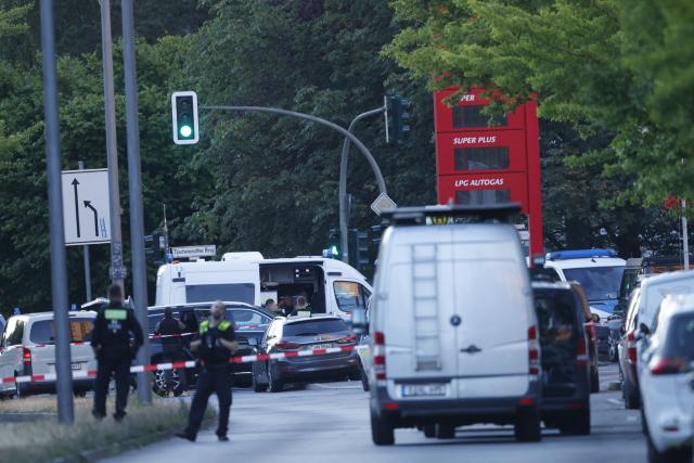 11 July 2026, Berlin: Police officers stand guard and secure a perimeter outside a supermarket, following reports of an active hostage situation inside the building. Special operations units have deployed to the scene, and local authorities have cordoned off the surrounding streets. Photo: Carsten Koall/dpa