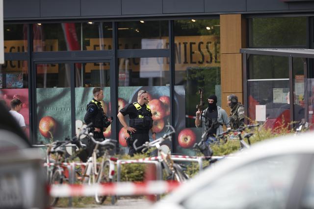 11 July 2026, Berlin: Police officers stand guard and secure a perimeter outside a supermarket, following reports of an active hostage situation inside the building. Police brought an end to the overnight crisis after a man held a woman hostage inside the store since late Friday evening. Photo: Carsten Koall/dpa