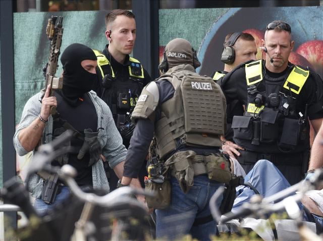 11 July 2026, Berlin: Emergency responders stand next to an injured person on a stretcher outside a supermarket. Police brought an end to the overnight crisis after a man held a woman hostage inside the store since late Friday evening. Photo: Carsten Koall/dpa