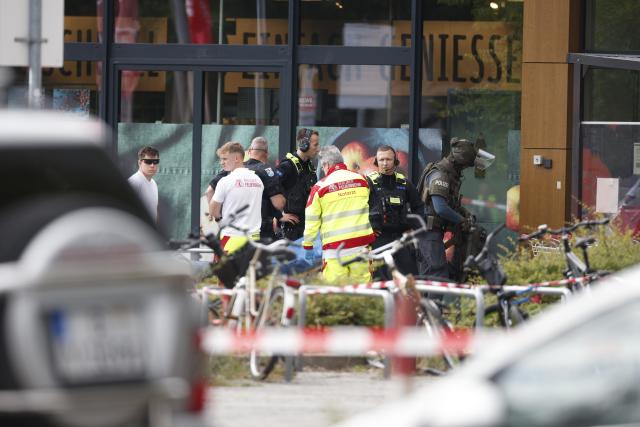 11 July 2026, Berlin: Emergency responders stand next to an injured person on a stretcher outside a supermarket. Police brought an end to the overnight crisis after a man held a woman hostage inside the store since late Friday evening. Photo: Carsten Koall/dpa