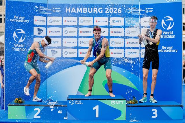 11 July 2026, Hamburg: (L-R) Portugal's Second-placed Vasco Vilaca, Australia's winner Matthew Hauser, and Germany's third-placed Henry Graf celebrate on the podium after the men's sprint race at the ITU World Triathlon Series/World Championship, comprising a 750-metre swim, a 20-kilometre bike ride and a five-kilometre run. Photo: Philipp Szyza/dpa
