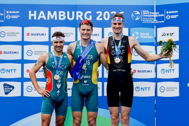 11 July 2026, Hamburg: (L-R) Portugal's Second-placed Vasco Vilaca, Australia's winner Matthew Hauser, and Germany's third-placed Henry Graf celebrate on the podium after the men's sprint race at the ITU World Triathlon Series/World Championship, comprising a 750-metre swim, a 20-kilometre bike ride and a five-kilometre run. Photo: Philipp Szyza/dpa