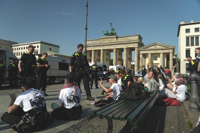 13 July 2026, Berlin: Police officers stand on duty at the Brandenburg Gate during a protest against defence contractor Rheinmetall in Berlin, Germany. Photo: Sven Kaeuler/dpa