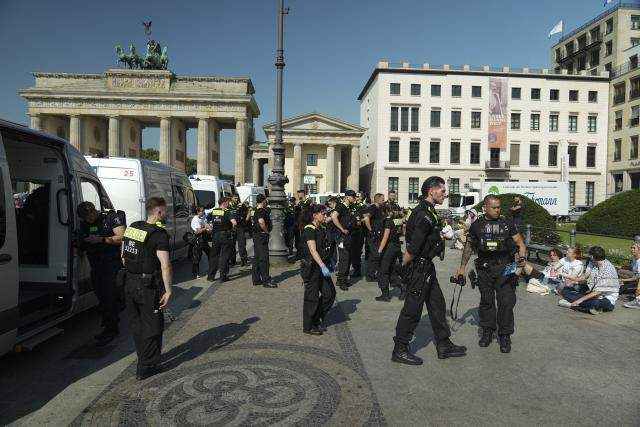 13 July 2026, Berlin: Police officers stand on duty at the Brandenburg Gate during a protest against defence contractor Rheinm
etall in Berlin. Photo: Sven Kaeuler/dpa