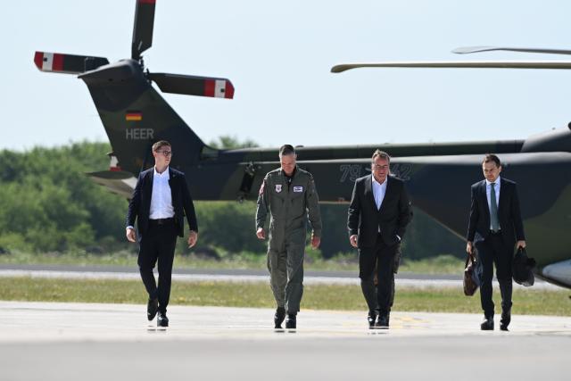 13 July 2026, Lower Saxony, Wittmund: Boris Pistorius (2nd R), Germany's Minister of Defence, walks across a field after arriving by helicopter for a visit to Tactical Air Force Wing 71 "Richthofen" at Wittmund Air Base in Wittmund, Germany. He is meeting soldiers from the wing. Photo: Lars Penning/dpa