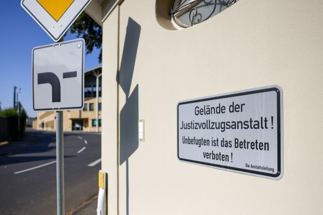 14 July 2026, North Rhine-Westphalia, Rheinbach: A sign points to the Rheinbach Correctional Facility in Rheinbach. Police searched rooms at the prison as well as apartments in North Rhine-Westphalia and Rhineland-Palatinate as part of an operation. Photo: Thomas Banneyer/dpa