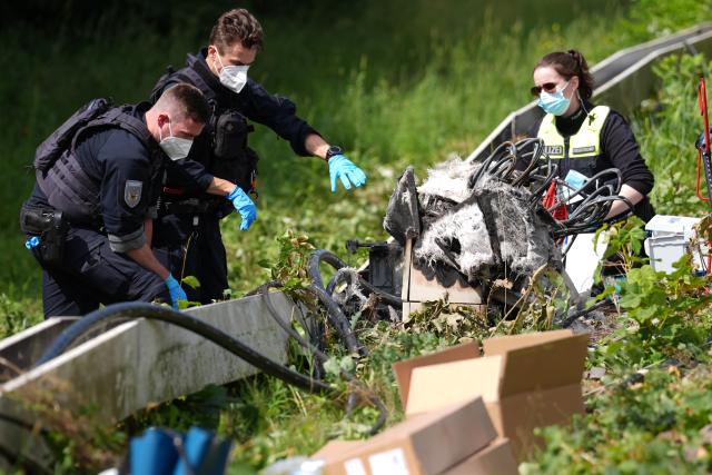 14 July 2026, Lower Saxony, Neu Wulmstorf: Police are securing evidence at the scene near the charred distribution box following a suspected arson attack on the railroad line between Hamburg and Cuxhaven. Train service has been suspended following a fire on the railroad line between Hamburg and Cuxhaven. Police reported that a distribution box caught fire overnight in Neu Wulmstorf, Lower Saxony. Photo: Marcus Brandt/dpa