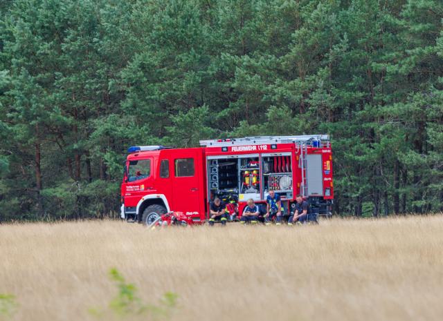 14 July 2026, Mecklenburg-Western Pomerania, Granzin: Fire department units are stationed at the edge of a forest in Mueritz National Park. 
The fire at the former tank firing range has spread to about 15.5 hectares and has not grown in size since the previous evening. Photo: Jens Büttner/dpa