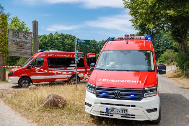 14 July 2026, Mecklenburg-Western Pomerania, Granzin: Firefighters are stationed on an access road to Müritz National Park. 
The fire at the former tank firing range has spread to about 15.5 hectares and has not grown in size since the previous evening. Photo: Jens Büttner/dpa