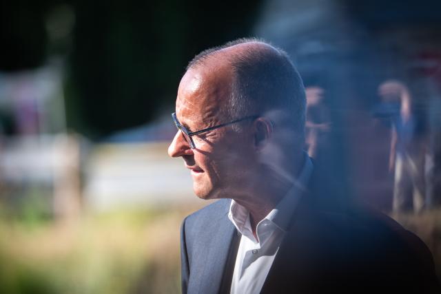 14 July 2026, Rhineland-Palatinate, Bad Neuenahr-Ahrweiler: German Chancellor Friedrich Merz looks out over the Ahr River during a tour of the municipal construction site in the Kurpark, on the anniversary of the 2021 European floods. During the flood disaster in the summer of 2021, 136 people died in Rhineland-Palatinate, 135 of them in the Ahr Valley. Photo: Hannes P. Albert/dpa