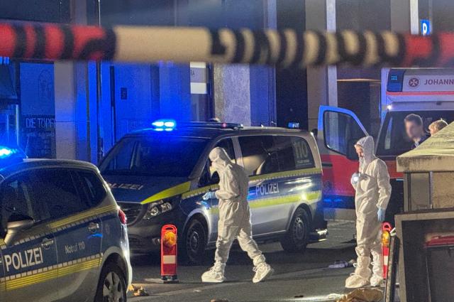 15 July 2026, Hesse, Kelkheim: Forensic investigators examine the scene in Kelkheim, after a man allegedly killed his wife with a bladed weapon on a public street. Photo: Mike Seeboth/dpa - ACHTUNG: Personen wurden aus rechtlichen Gründen gepixelt.