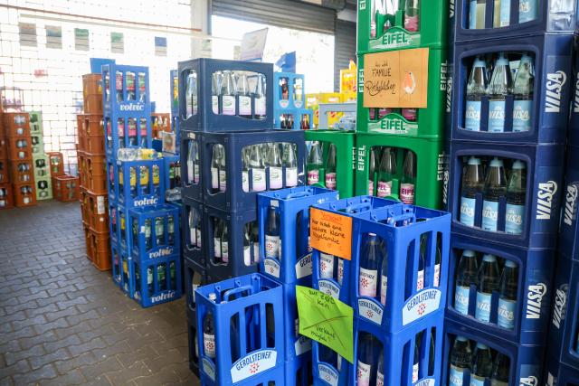 15 July 2026, North Rhine-Westphalia, Bottrop: Three young robins nest among stacks of beverage crates inside a drinks store. Photo: Christoph Reichwein/dpa