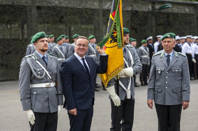 15 July 2026, Berlin: German Defense Minister Boris Pistorius holds a ribbon during a visit to the Guard Battalion at the Julius Leber Barracks. Photo: Christophe Gateau/dpa