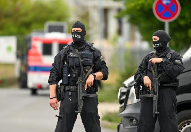 15 July 2026, Brandenburg, Ludwigsfelde: Armed police officers are blocking access to a warehouse on Gottlieb-Daimler-Strasse in the Ost Industrial Park. Customs, police, and the Federal Agency for Technical Relief were on the scene to raid a suspected drug lab. Photo: Soeren Stache/dpa