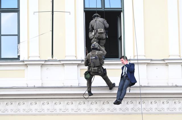 18 July 2026, Bavaria, Munich: Bavaria's State Secretary of the Interior, Sandro Kirchner (R), takes part in a practical demonstration by the SEK, during which he rappels down from a building-the Bavarian Ministry of the Interior on Odeonsplatz-as part of the "80 Years of the Bavarian Police" celebration. Photo: Felix Hörhager/dpa