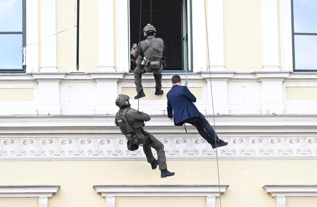 18 July 2026, Bavaria, Munich: Bavaria's State Secretary of the Interior, Sandro Kirchner (R), takes part in a practical demonstration by the SEK, during which he rappels down from a building-the Bavarian Ministry of the Interior on Odeonsplatz-as part of the "80 Years of the Bavarian Police" celebration. Photo: Felix Hörhager/dpa