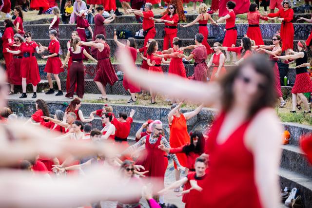 18 July 2026, Berlin: Participants dance during the "Wuthering Heights Day" event in Goerlitzer Park in Berlin. The global event sees people dressed in red reenact the choreography from the music video for Kate Bush's 1978 song "Wuthering Heights." Photo: Christoph Soeder/dpa