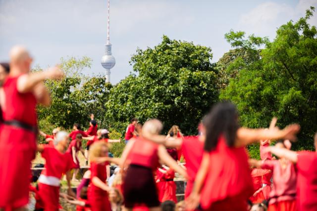 18 July 2026, Berlin: Participants dance during the "Wuthering Heights Day" event in Goerlitzer Park in Berlin. The global event sees people dressed in red reenact the choreography from the music video for Kate Bush's 1978 song "Wuthering Heights." Photo: Christoph Soeder/dpa