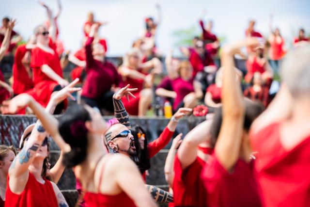 18 July 2026, Berlin: Participants dance during the "Wuthering Heights Day" event in Goerlitzer Park in Berlin. The global event sees people dressed in red reenact the choreography from the music video for Kate Bush's 1978 song "Wuthering Heights." Photo: Christoph Soeder/dpa