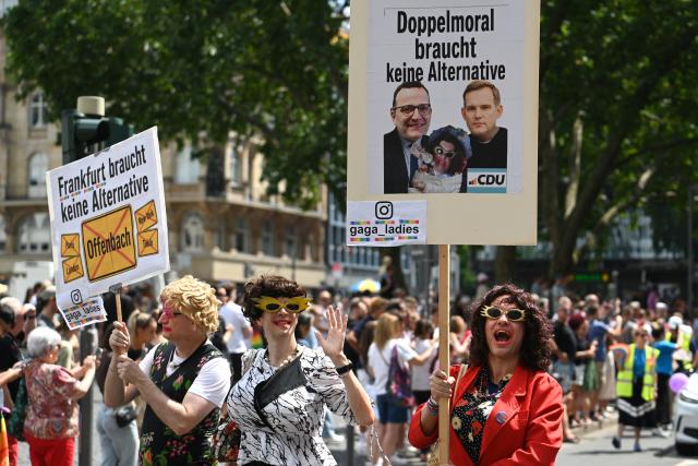 18 July 2026, Hesse, Frankfurt am Main: Participants hold a placard depicting CDU politicians Jens Spahn and Hendrik Streeck during Christopher Street Day (CSD) in Frankfurt am Main. Spahn resigned from his post earlier today. This year's CSD is held under the motto "Democracy needs no alternative!" Photo: Lea Winkler/dpa