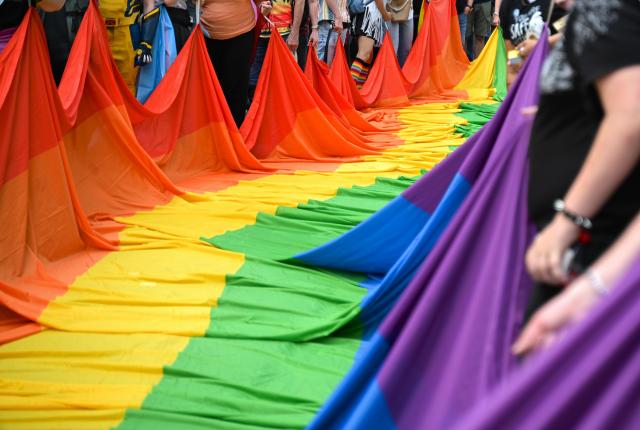 18 July 2026, Hesse, Frankfurt am Main: Participants unfurl a large rainbow flag during Christopher Street Day (CSD) in Frankfurt am Main. This year's CSD is held under the motto "Democracy needs no alternative!" Photo: Lea Winkler/dpa