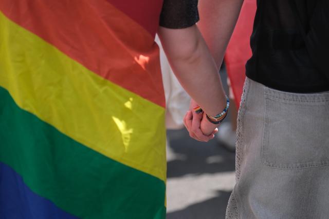 18 July 2026, Saxony, Leipzig: Participants hold hands during the Christopher Street Day (CSD) parade in Leipzig. Around 20,000 people were expected to attend the annual event. Photo: Sebastian Willnow/dpa