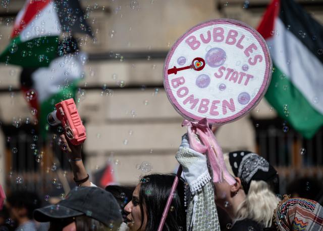 18 July 2026, Hesse, Frankfurt am Main: A participant waves during a pro-Palestinian demonstration outside the Alte Oper in Frankfurt am Main, Germany. The demonstration is held under the slogan: "Resistance is international law - Palestine has the right to defend itself, even with stones and guns!" Photo: Hannes P. Albert/dpa
