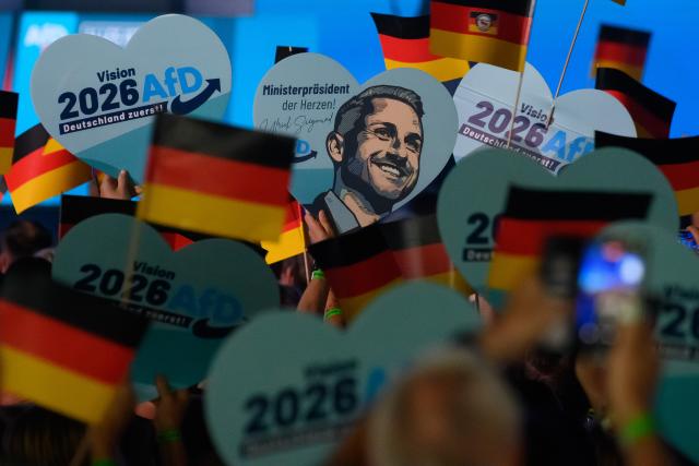 18 July 2026, Saxony-Anhalt, Magdeburg: Participants wave German flags and hold heart-shaped placards bearing the portrait of the AfD's lead candidate as they wait for the start of the AfD Saxony-Anhalt election campaign launch in Magdeburg. The state election in Saxony-Anhalt will be held on 6 September 2026. Photo: Klaus-Dietmar Gabbert/dpa
