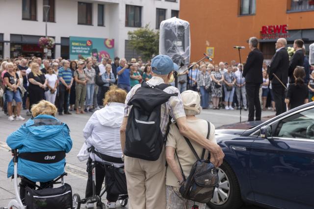 18 July 2026, Hesse, Kelkheim: People pay tribute to the woman who was killed in the fatal machete attack in Kelkheim. Following the homicide, the city of Kelkheim invited the public to attend a memorial service. Photo: Helmut Fricke/dpa