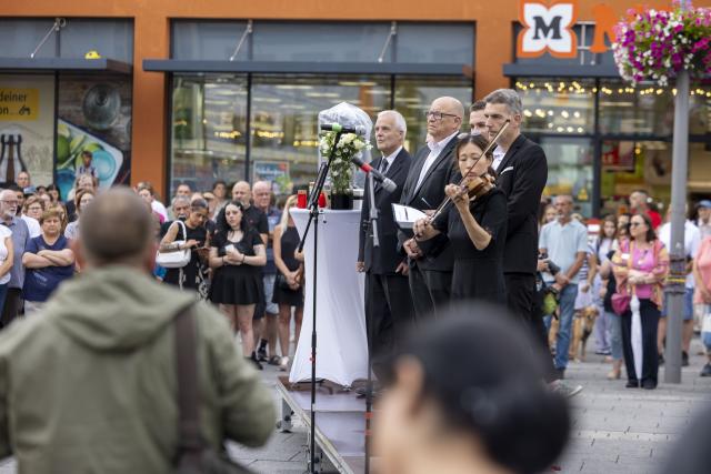18 July 2026, Hesse, Kelkheim: People pay tribute to the woman who was killed in the fatal machete attack in Kelkheim. Following the homicide, the city of Kelkheim invited the public to attend a memorial service. Photo: Helmut Fricke/dpa
