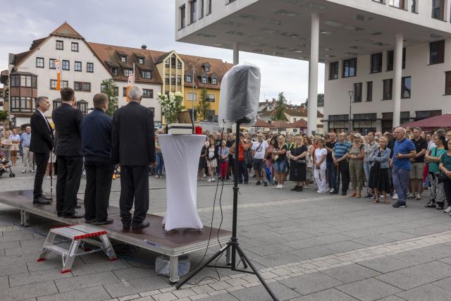 18 July 2026, Hesse, Kelkheim: People pay tribute to the woman who was killed in the fatal machete attack in Kelkheim. Following the homicide, the city of Kelkheim invited the public to attend a memorial service. Photo: Helmut Fricke/dpa