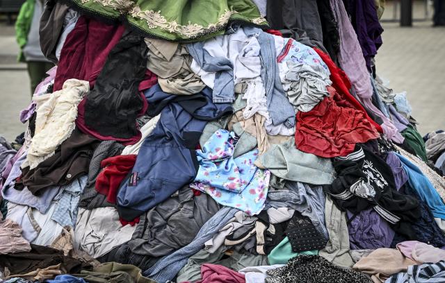 FILED - 22 October 2025, Berlin: File Photo - A large pile of discarded textile waste pictured during a demonstration against the fast fashion industry in front of the Brandenburg Gate. Photo: Jens Kalaene/dpa