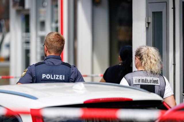 19 July 2026, Bavaria, Nuremberg: Police officers stand at the scene outside an amusement arcade where an employee was killed. Police said a 45-year-old suspect was arrested nearby. Photo: -/dpa