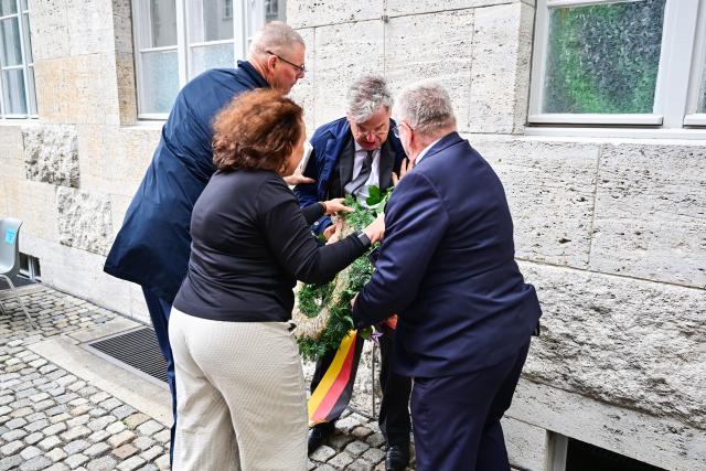 20 July 2026, Berlin: Tobias Korenke (2-R), a descendant of prominent German resistance fighters, stands by the destroyed wreath of the Alternative for Germany (AfD) party during a memorial ceremony in the inner courtyard of the Bendlerblock. Photo: Sebastian Christoph Gollnow/dpa